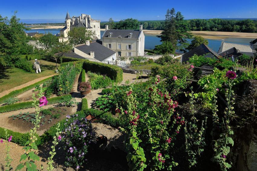 sous un ciel bleu, vue d'un jardin, du château de Montsoreau et de la Loire en fond